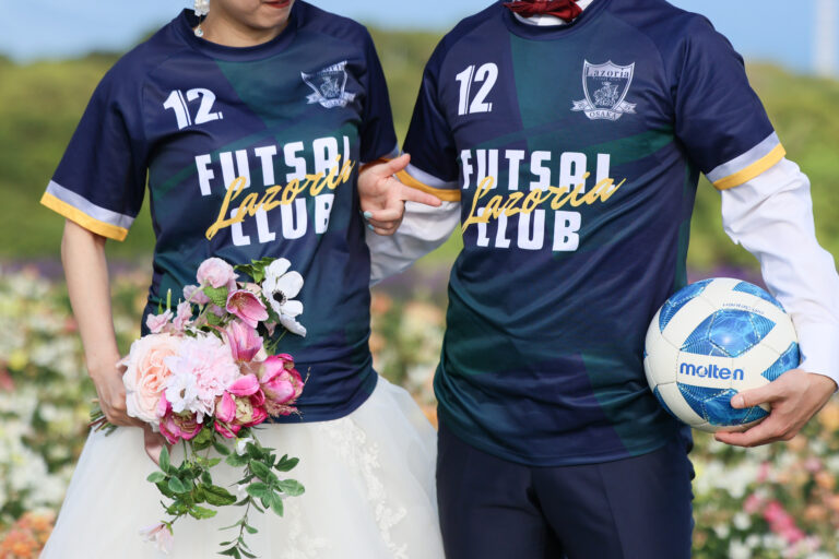 おそろいのフットサルユニフォームを着てボールを持つ新郎新婦